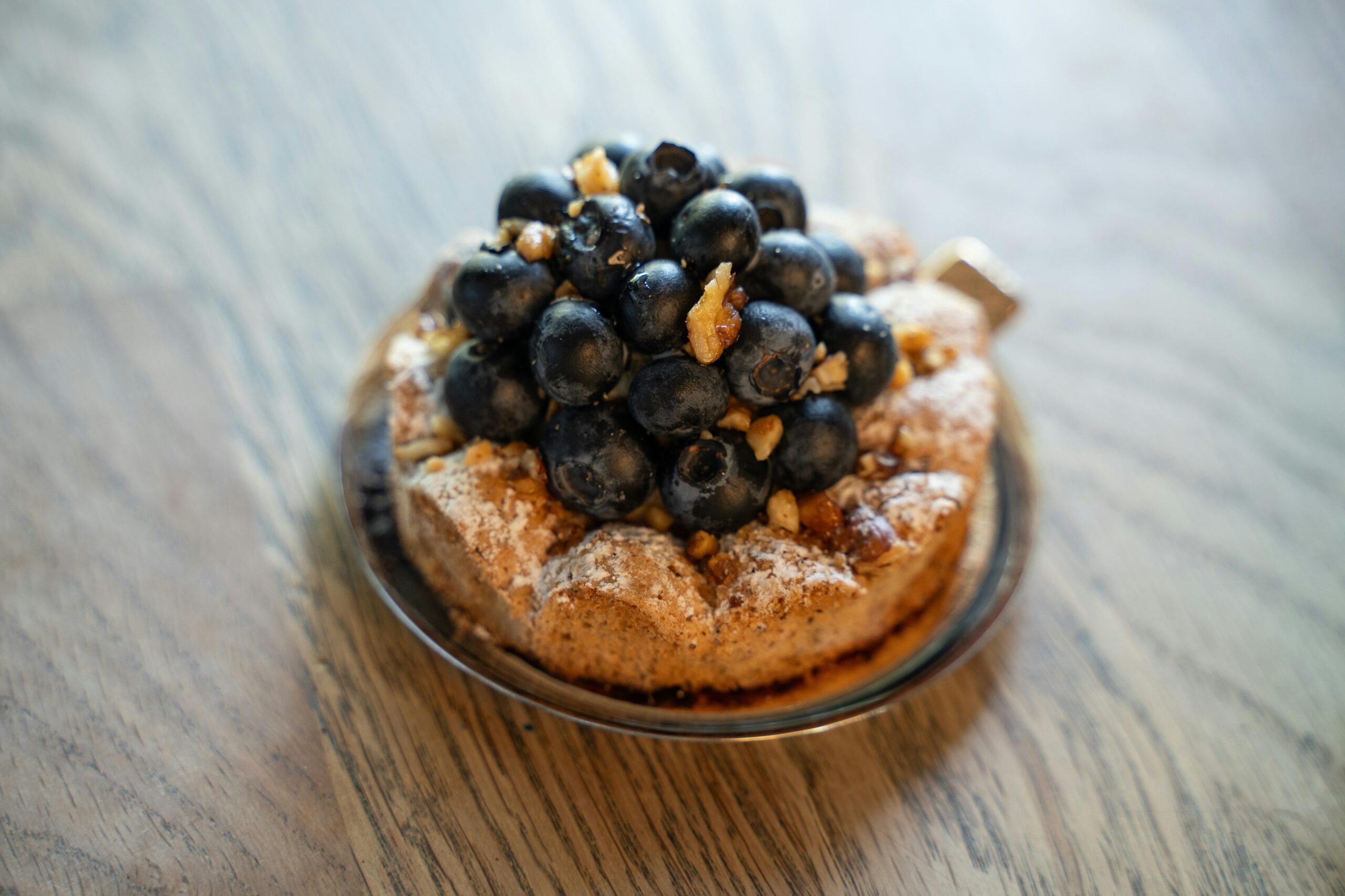 Indulge in a delectable blueberry tart topped with nuts, capturing the essence of European pastry delight.
