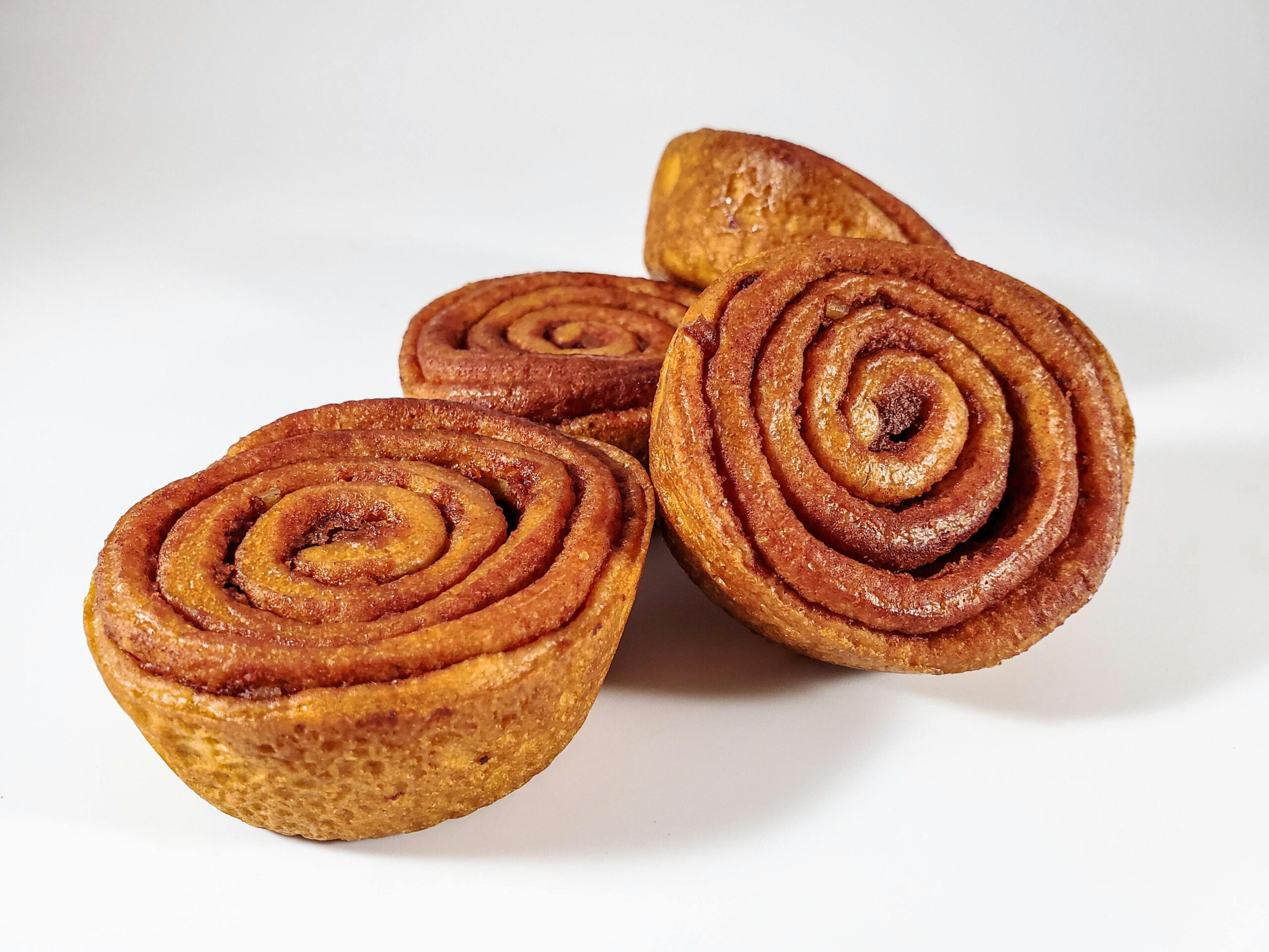 Close-up of freshly baked cinnamon rolls on a white background, ready to eat.